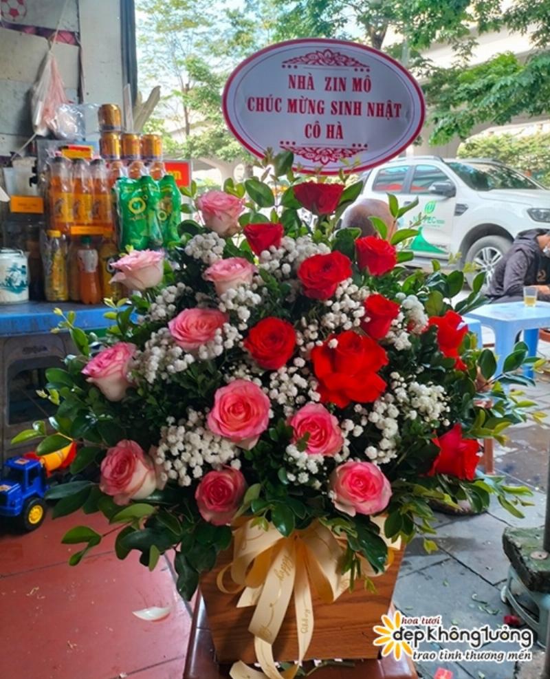 Một kệ trưng bày đa dạng các loại hoa tươi phổ biến như hoa hồng, cẩm chướng, ly, hướng dương trong một shop hoa sáng sủa